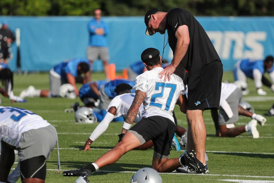 El entrenador en jefe de los Detroit Lions, Dan Campbell, habla con el esquinero Chase Lucas durante el calentamiento durante el campamento de entrenamiento en la sede y las instalaciones de entrenamiento de los Detroit Lions en Allen Park el domingo 23 de julio de 2023.