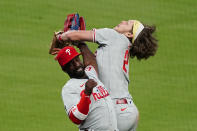 Philadelphia Phillies third baseman Alec Bohm (28) collides with left fielder Andrew McCutchen (22) as he catches a Atlanta Braves' Ozzie Albies pop fly in foul territory in eighth inning of a baseball game Saturday, April 10, 2021, in Atlanta. (AP Photo/John Bazemore)