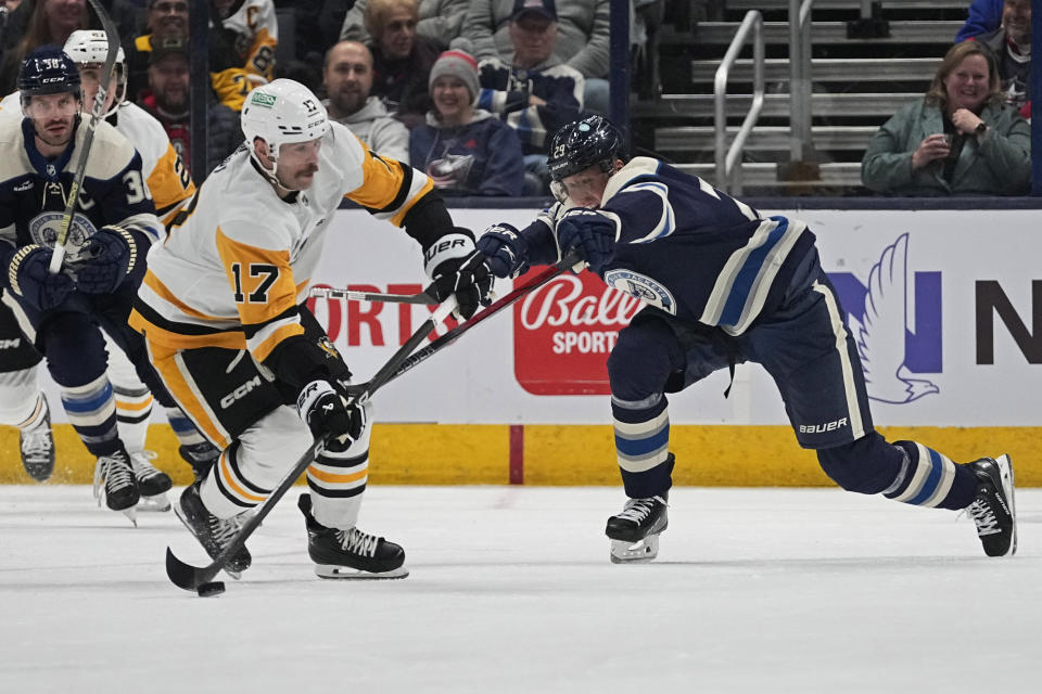 Columbus Blue Jackets right wing Patrik Laine (29) reaches for the puck controlled by Pittsburgh Penguins right wing Bryan Rust (17) during the first period of an NHL hockey game Tuesday, Nov. 14, 2023, in Columbus, Ohio. (AP Photo/Sue Ogrocki)