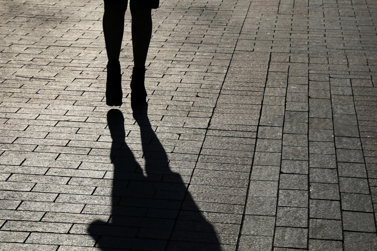 A lone woman walking on the street. 