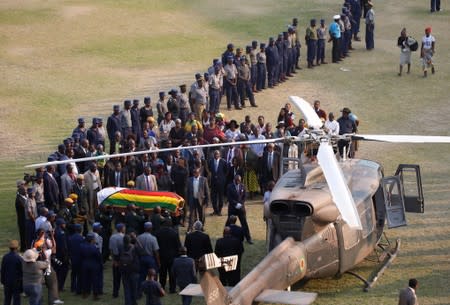 The casket carrying the body of former Zimbabwean President Robert Mugabe is carried to the military chopper after lying in state at the Rufaro stadium