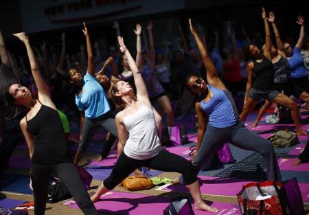 People take part in a group yoga practice on the morning of the summer solstice in New York's Times Square, June 21, 2013. REUTERS/Eric Thayer