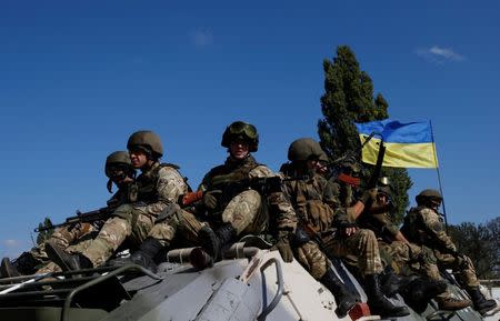 Ukrainian servicemen ride on an armoured vehicle near the eastern Ukrainian town of Pervomaysk, September 17, 2014. REUTERS/David Mdzinarishvili