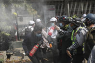 Anti-coup protesters discharge fire extinguishers to counter the impact of the tear gas fired by police during a demonstration in Mandalay, Myanmar, Sunday, March 7, 2021. The escalation of violence in Myanmar as authorities crack down on protests against the Feb. 1 coup is raising pressure for more sanctions against the junta, even as countries struggle over how to best sway military leaders inured to global condemnation. (AP Photo)