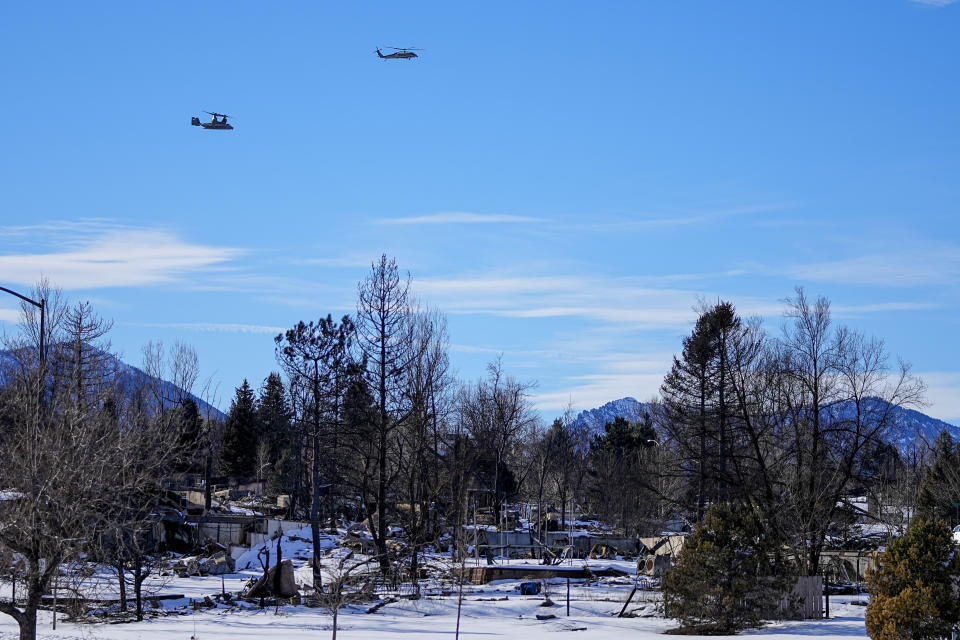Helicopters flying President Joe Biden pass over homes burned by the Marshall Fire Friday, Jan. 7, 2022, in Louisville, Colo. The Marshall fire destroyed nearly 1,000 homes. (AP Photo/Jack Dempsey)