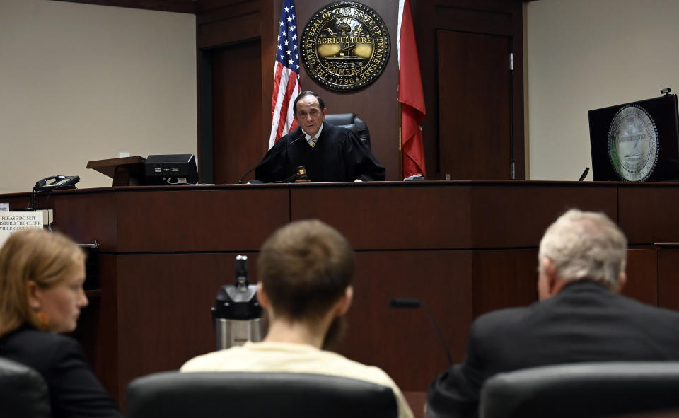 Criminal Court Judge Dee David Gay talks to Michael Cummins, bottom center, about the sentencing at the Sumner County Justice Center on Wednesday, Aug. 16, 2023, in Gallatin Tenn. Cummins who killed eight people in rural Westmoreland over several days in April 2019, has pleaded guilty to eight counts of first-degree murder in exchange for a sentence of life without parole. (Mark Zaleski/The Tennessean via AP, Pool)