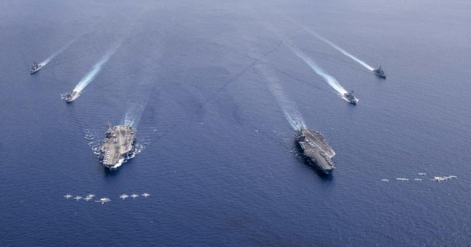 Aircraft from Carrier Air Wing 5 and Carrier Air Wing 17 fly in formation over the Nimitz Carrier Strike Force (CSF). The USS Nimitz (CVN 68) and USS Ronald Reagan (CVN 76) Carrier Strike Groups are conducting dual carrier operations in the Indo-Pacific as the Nimitz CSF.