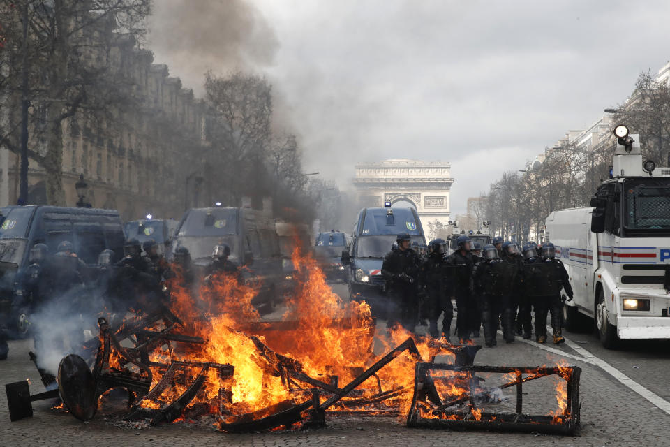 A barricade burns on the Champs Elysees avenue Saturday, March 16, 2019 in Paris. French yellow vest protesters clashed Saturday with riot police near the Arc de Triomphe as they kicked off their 18th straight weekend of demonstrations against President Emmanuel Macron. (AP Photo/Christophe Ena)