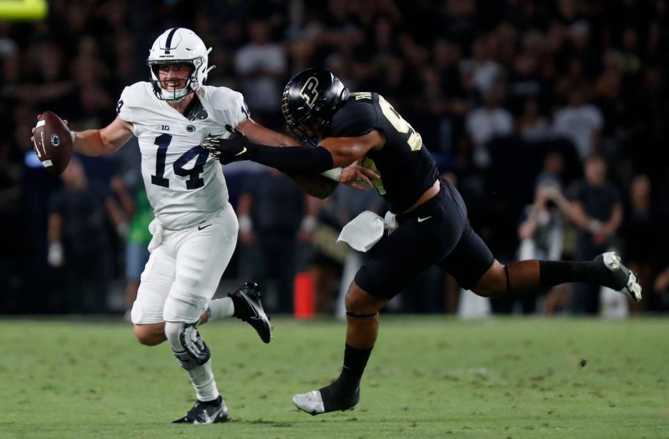 Penn State Nittany Lions quarterback Sean Clifford (14) is rushed by Purdue Boilermakers linebacker Semisi Fakasiieiki (97) during the NCAA football game, Thursday, Sept. 1, 2022, at Ross-Ade Stadium in West Lafayette, Ind. 