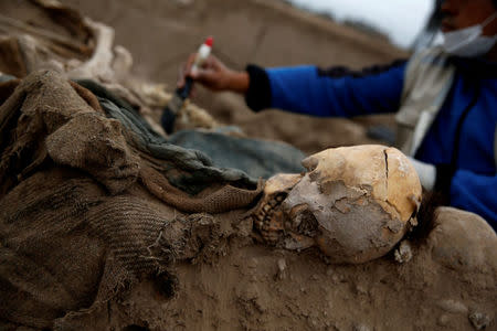 Archaeologist works at a tomb of one of sixteen Chinese migrants, discovered buried at the turn of the 20th century in the pre-colombian pyramid of Bellavista, according to Ministry of Culture, in Lima, Peru, August 24, 2017. REUTERS/Mariana Bazo