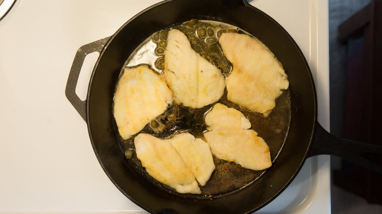 flounder cooking in piccata sauce