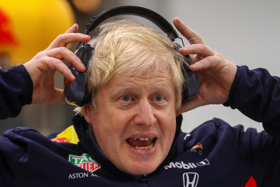 Britain's Prime Minister Boris Johnson adjusts his safety headphones during a visit at Red Bull Racing in Milton Keynes, Britain December 4, 2019. REUTERS/Hannah McKay/Pool