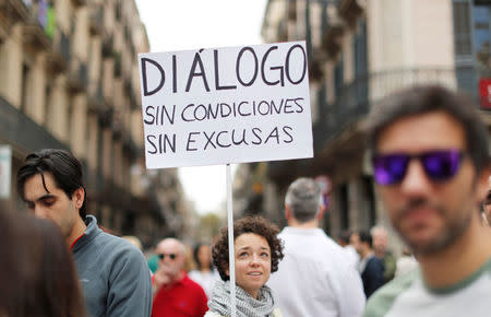 A woman holds a placard during a demonstration in favour of dialogue in a square in Barcelona, Spain, October 7, 2017 REUTERS/Gonzalo Fuentes