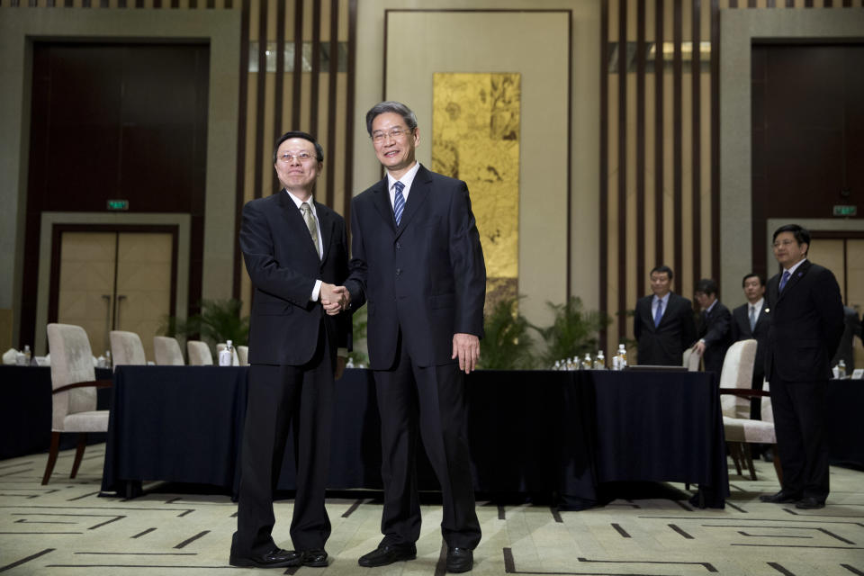 Wang Yu-chi, head of Taiwan's Mainland Affairs Council, left, and Zhang Zhijun, director of China's Taiwan Affairs Office, right, shake hands and pose for photos before their meeting in Nanjing, in eastern China's Jiangsu Province, Tuesday, Feb. 11, 2014. Taiwan and China are holding their highest-level talks since splitting amid a civil war 65 years ago, hoping to further boost contacts and ease lingering tensions, even as political developments on the self-governing island swing away from Beijing's goal of eventual unification. (AP Photo/Alexander F. Yuan)