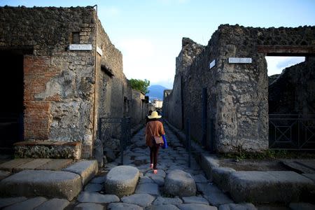 A tourist (C) walks along an ancient Roman cobbled street at the UNESCO World Heritage site of Pompeii, October 13, 2015. REUTERS/Alessandro Bianchi