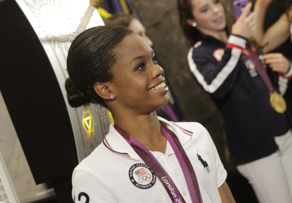 U.S. Women's Gymnastics Olympic team gold-medal winner Gabby Douglas poses with team members at the Empire State Building, Tuesday, Aug. 14, 2012 in New York. (AP Photo/Alex Katz)