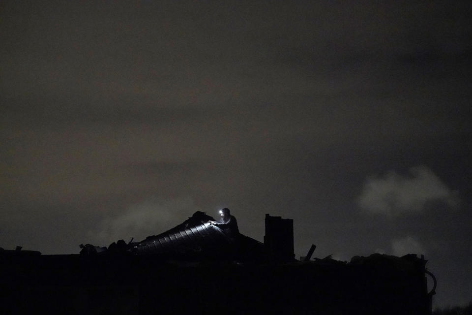 Cody Scott searches the attic for belongings after a tornado tore the roof off of his father-in-law's home, in Arabi, La., Tuesday, March 22, 2022. A tornado tore through parts of New Orleans and its suburbs Tuesday night, ripping down power lines and scattering debris in a part of the city that had been heavily damaged by Hurricane Katrina 17 years ago. (AP Photo/Gerald Herbert)