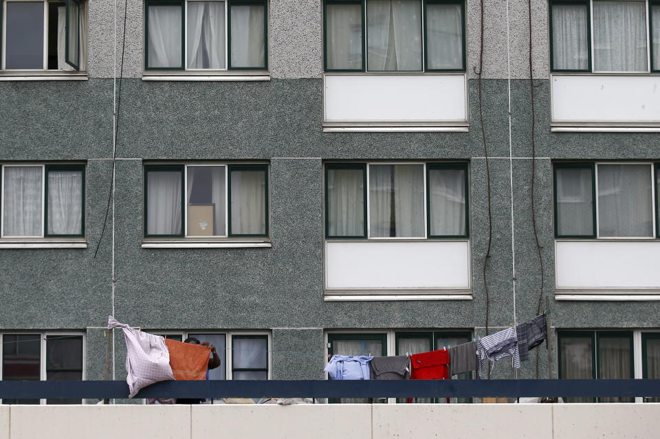 A person hangs laundry to dry outside an apartment on the Broadwater Farm estate in north London, Britain, December 30, 2015. Oliver Letwin, British Prime Minister David Cameron's policy chief, apologised on Wednesday after a newly released memo from 30 years ago revealed he had blamed poor morals in the black community for the 1985 riots in the Broadwater Farm estate and said any investment would be wasted on discos and drugs.  REUTERS/Peter Nicholls