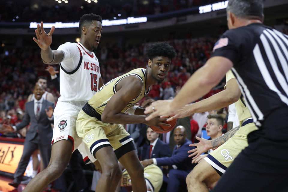 Georgia Tech's Khalid Moore (12) pulls in a loose ball after North Carolina State's Devon Daniels tried to throw the ball to Manny Bates (15) with less than 10 seconds left in an NCAA college basketball game Tuesday, Nov. 5, 2019, in Raleigh, N.C. (Ethan Hyman/The News & Observer via AP)