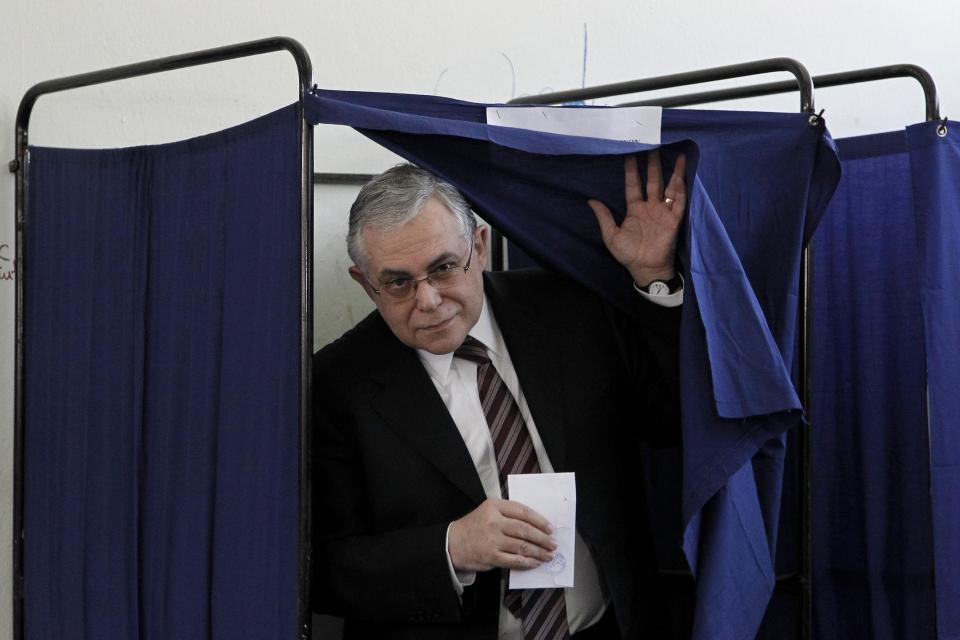 Greek Prime Minister Lucas Papademos leaves the booth to cast his vote at at a voting center , in Athens, Sunday, May 6, 2012. Greeks cast their ballots on Sunday in their most critical and uncertain elections in decades, with voters seemingly set to punish the two main parties that are being held responsible for the country's dire economic straits.(AP Photo/Petros Giannakouris)