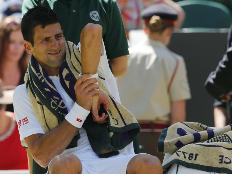 Novak Djokovic of Serbia stretches during a break between games of his match against Richard Gasquet of France at the Wimbledon Tennis Championships in London, July 10, 2015. REUTERS/Suzanne Plunkett