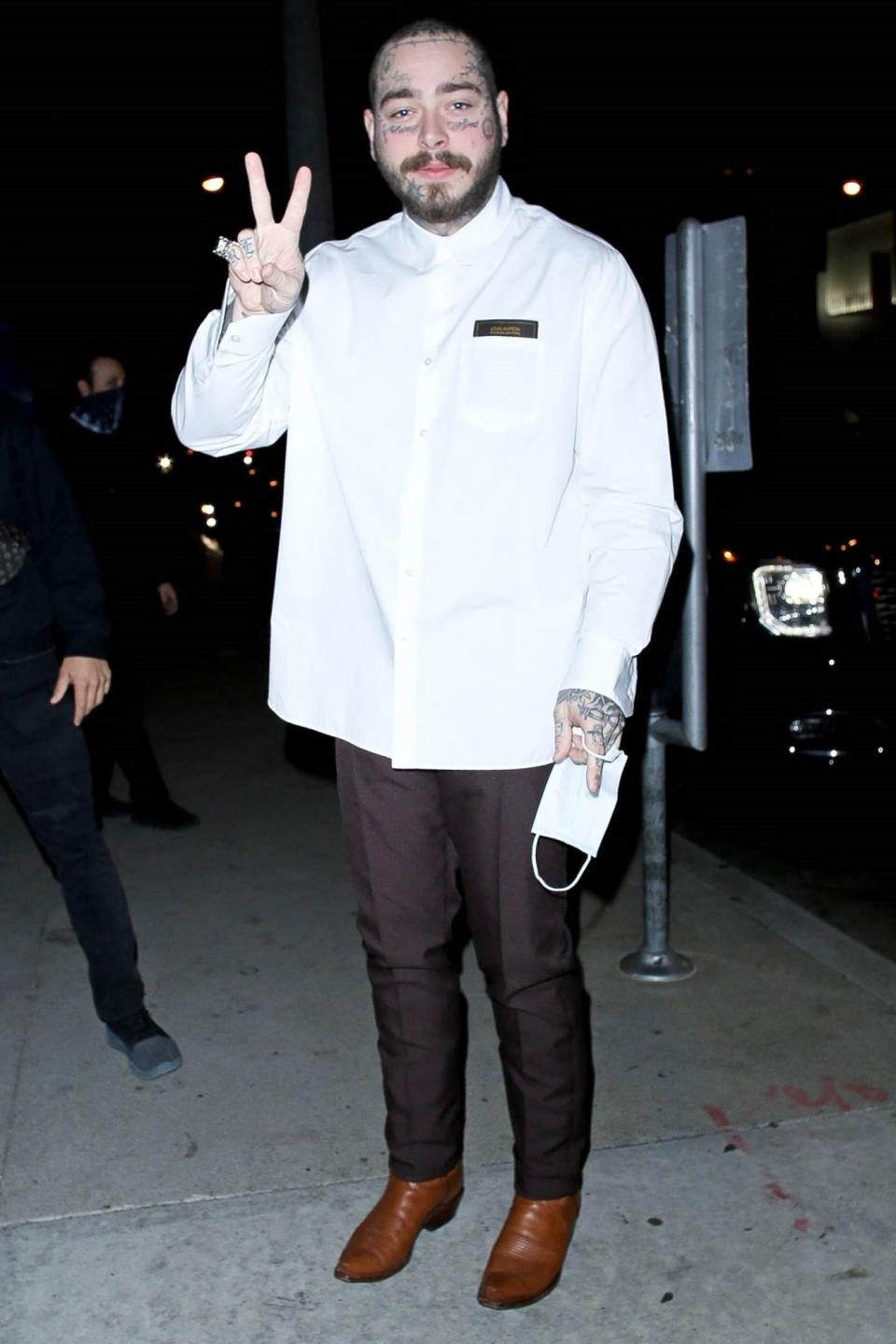 <p>Post Malone throws up a peace sign outside of BOA Steakhouse on Friday in West Hollywood.</p>