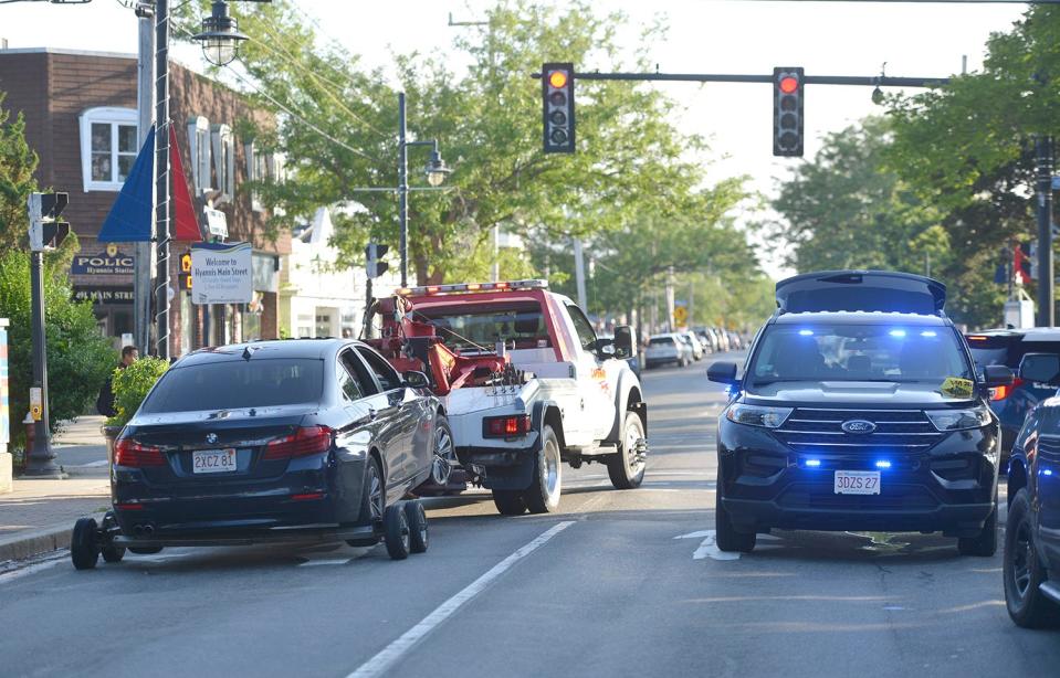 In this June 25 photo, a car is towed away from a spot near the intersection of Main Street and High School Road Extension in Hyannis. Police say a 16-year-old boy fired 11 rounds at a group of men he had argued with earlier. One man was shot in both legs and hospitalized. His injuries were serious but not life-threatening.