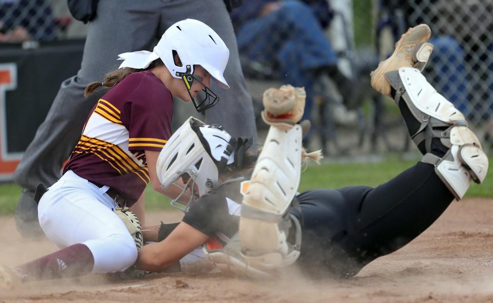Walsh Jesuit base runner Sienna Tepley, left, scores past Painesville Riverside catcher Delaney Keith on a hit by MaKayla McGee during the seventh inning of a Division I district semifinal softball game at Massillon High School on Monday.