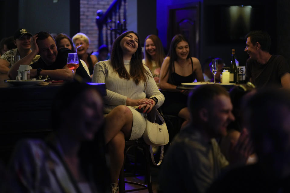 People attend Serhiy Lipko's stand-up comedy show in Kyiv, Ukraine, Saturday, June 11, 2022. The war in Ukraine isn't remotely funny, but Ukrainians are learning to laugh about the awfulness of it all. Not necessarily because they want to, but because they have to stay sane in the conflict that has killed tens of thousands and is turning Ukraine, millions of lives, and the world order inside out. (AP Photo/Natacha Pisarenko)