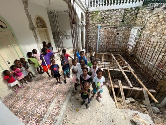 Kids at the Have Faith Haiti Mission & Orphanage stand where the kitchen is being built.