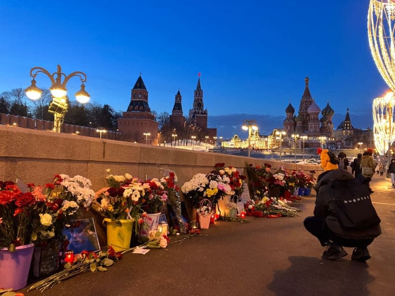 People lay flowers at the spot where Kremlin opponent Boris Nemtsov was shot dead in 2015. Hannah Wagner/dpa