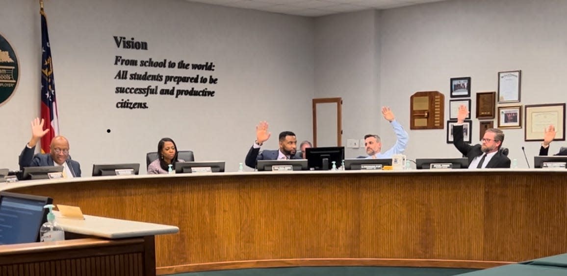Savannah-Chatham Public School System board members including president Roger Moss raise their hands during the unanimous vote to pass Phase 1 of the Long-Range Facility's plan.