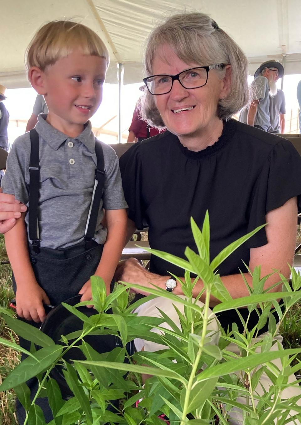 Jared Luke Troyer poses with Jean Holden after winning the drawing for eight potted swamp milkweed plants Jean and Art Holden gave away after their talk on monarch butterflies at the 18th annual Family Farm Field Days in Baltic.