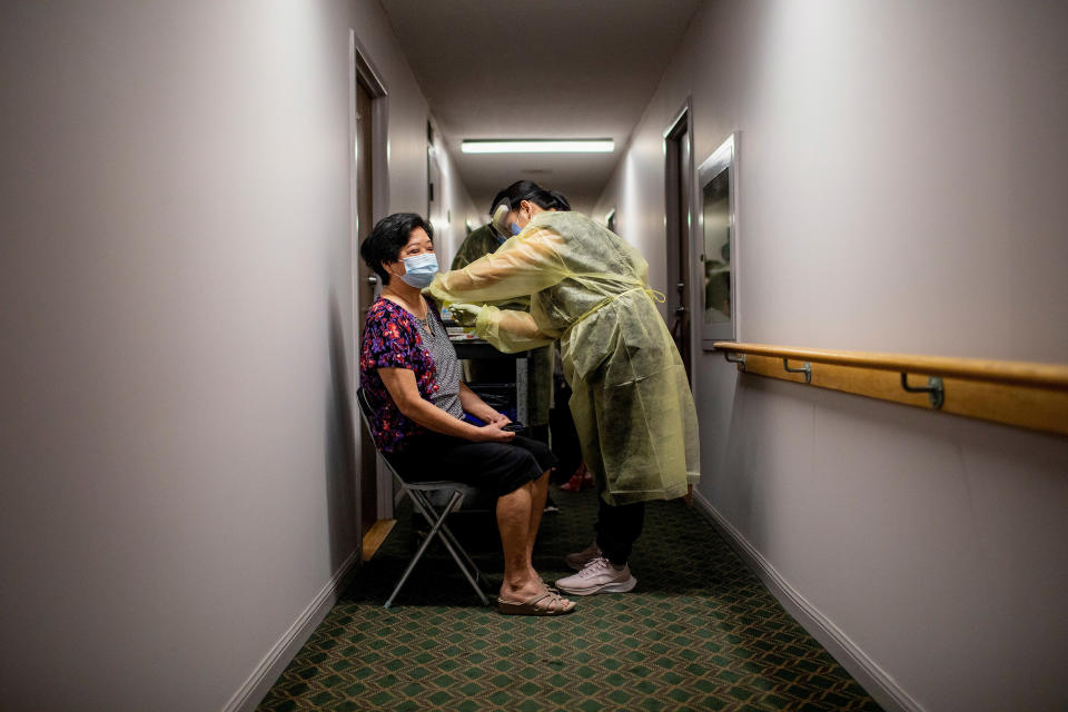 Catherine Serrano administers the Pfizer/BioNTech vaccine to a resident at Caboto Terrace, an independent seniors residence in Toronto, Canada. (Carlos Osorio / Reuters file)