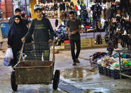 People shop at old Basra market, Iraq, Wednesday, Oct. 21, 2020. Iraq is in the throes of an unprecedented liquidity crisis, as the cash-strapped state wrestles to pay public sector salaries and import essential goods while oil prices remain dangerously low. (AP Photo/Nabil al-Jurani)