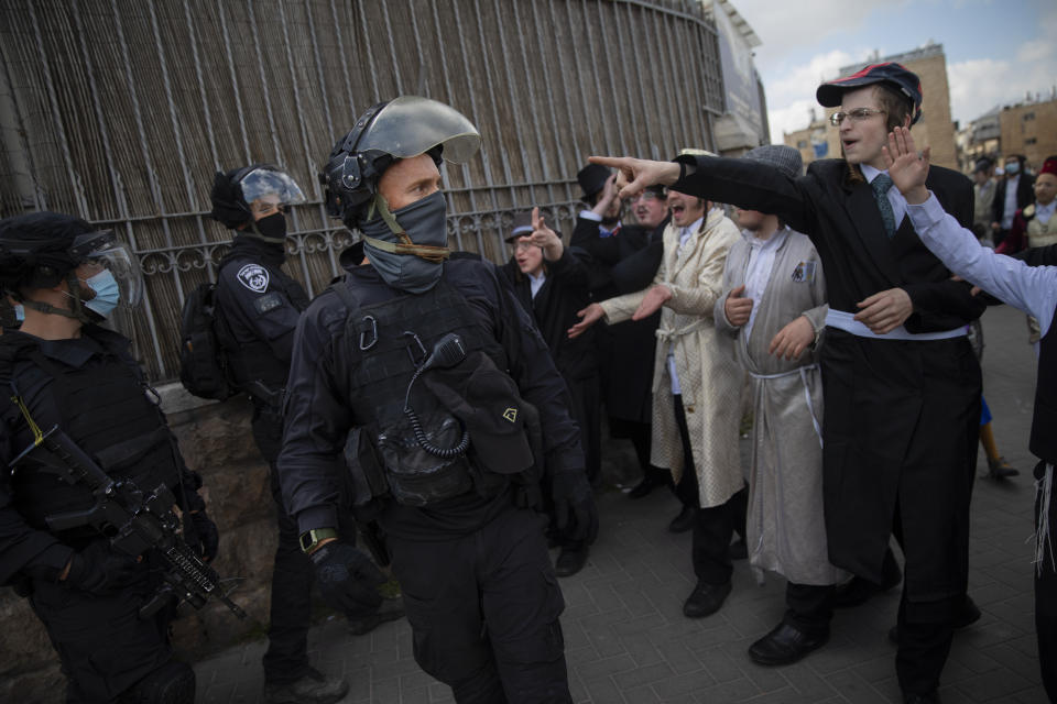 Ultra-Orthodox Jews some wearing costumes scuffle with police officers during celebrations of the Jewish holiday of Purim, in the Mea Shearim ultra-Orthodox neighborhood of Jerusalem, Sunday, Feb. 28, 2021. The Jewish holiday of Purim commemorates the Jews' salvation from genocide in ancient Persia, as recounted in the biblical Book of Esther. (AP Photo/Oded Balilty)