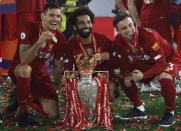 Liverpool's Mohamed Salah, ceter, and Liverpool's Xherdan Shaqiri, right, and Liverpool's Dejan Lovren pose with the English Premier League trophy following its presentation after the English Premier League soccer match between Liverpool and Chelsea at Anfield Stadium in Liverpool, England, Wednesday, July 22, 2020. Liverpool are champions of the EPL for the season 2019-2020. The trophy is presented at the teams last home game of the season. Liverpool won the match against Chelsea 5-3. (Phil Noble/Pool via AP)