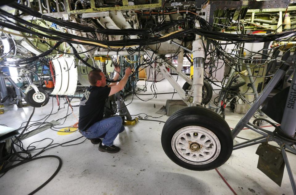 An aircraft mechanic works on then underside of an F-16 Falcon at Hill Air Force base in Ogden, Utah. (Photo by George Frey/Getty Images)