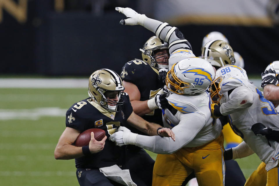 New Orleans Saints quarterback Drew Brees (9) tries to avoid the sack by Los Angeles Chargers defensive tackle Linval Joseph (95) in the second half of an NFL football game in New Orleans, Monday, Oct. 12, 2020. (AP Photo/Brett Duke)