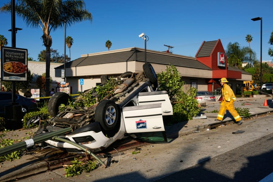 Los Angeles fire department firefighters arrive at the scene of a car crash in front of a fast food restaurant near downtown Los Angeles on Thursday, Oct. 6, 2016. The traffic accident left a vehicle overturned on a sidewalk and another smashed-up car in the drive-thru lane of a fast-food restaurant. (AP Photo/Richard Vogel)