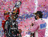Third placed Ferrari driver Sebastian Vettel of Germany, left, pours champagne of race winner Mercedes driver Lewis Hamilton of Britain, as Racing Point driver Sergio Perez, right, of Mexico who finished second looks on the podium of the Formula One Turkish Grand Prix at the Istanbul Park circuit racetrack in Istanbul, Sunday, Nov. 15, 2020. (AP Photo/Kenan Asyali, Pool)