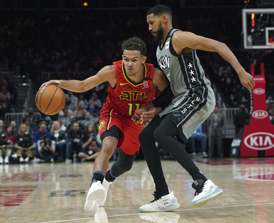 Brooklyn Nets guard Garrett Temple, right, defends against Atlanta Hawks Trae Young (11) in the second half of an NBA basketball game Friday, Feb. 28, 2020, in Atlanta. (AP Photo/Tami Chappell)