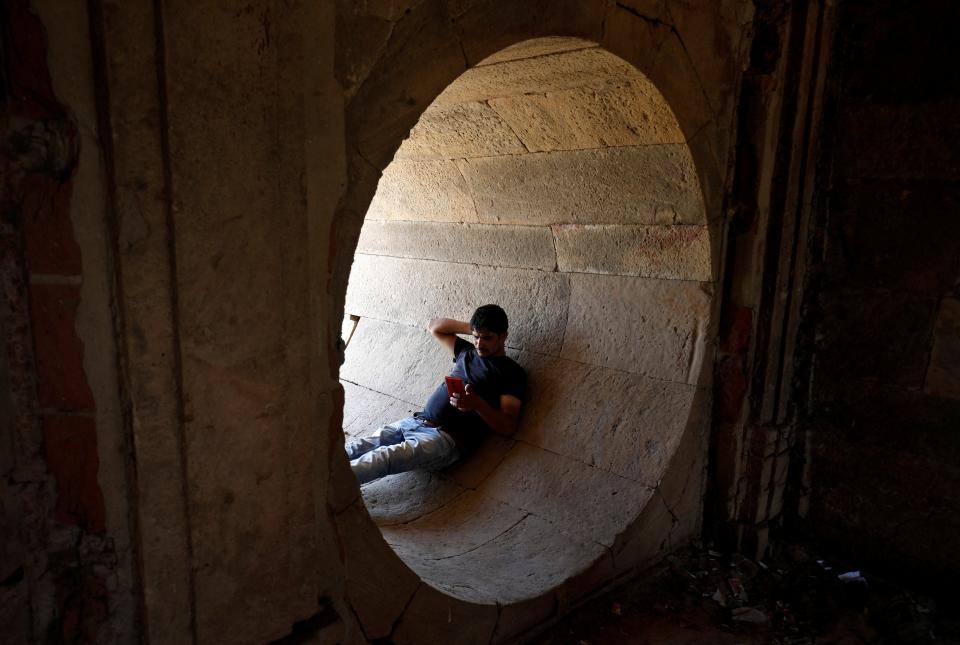 A man rests in a dry water tunnel of Sarkhej Roza lake during hot weather in Ahmedabad (Reuters)