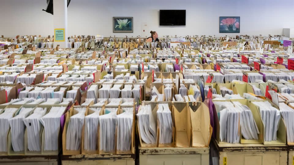 In this June 2022 photo, Margaret Moore, an IRS clerk, searches through taxpayer documents that have been stored in the cafeteria due to a lack of space at the IRS campus in Austin, Texas. - Matthew Busch/The Washington Post/Getty Images/File