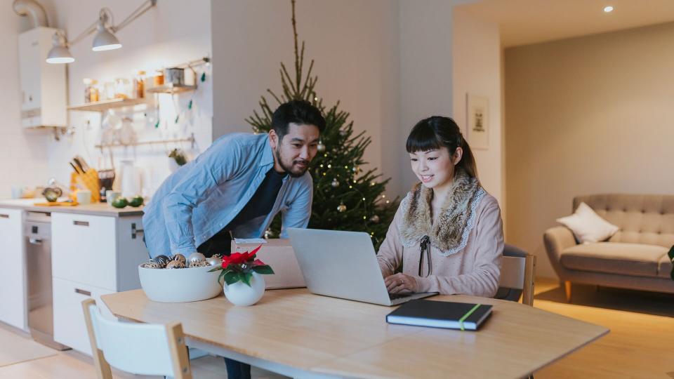 Happy Japanese couple at home, having video conference call with the parents.