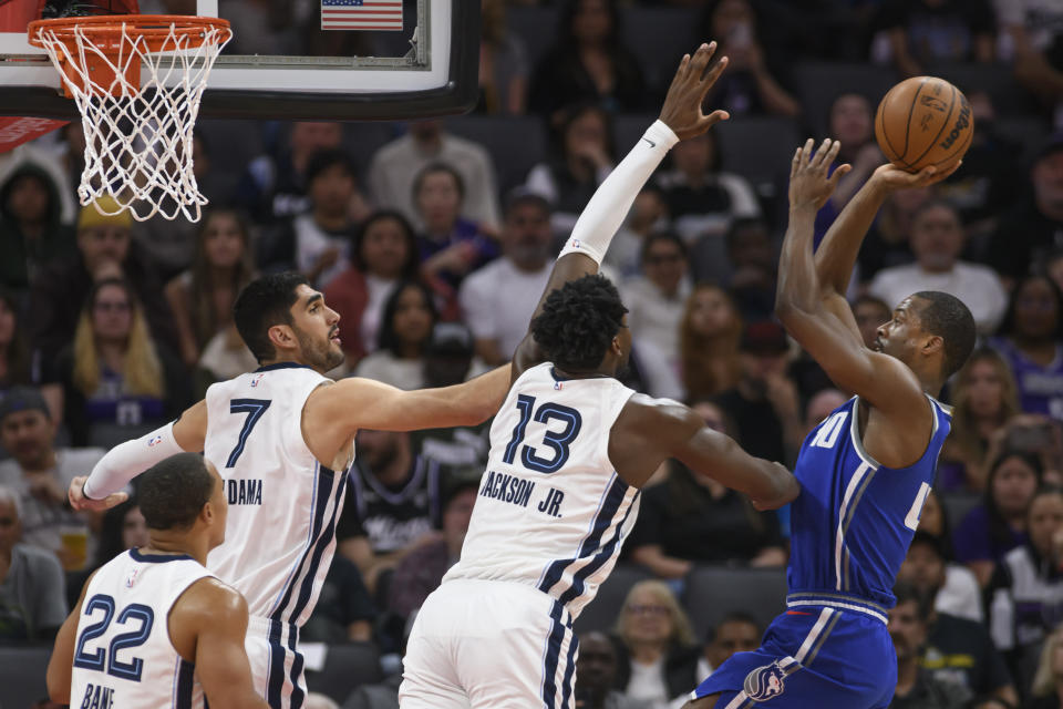 Memphis Grizzlies forward Santi Aldama (7) and forward Jaren Jackson Jr. (13) guard the basket as Sacramento Kings forward Harrison Barnes shoots during the first half of an NBA basketball game in Sacramento, Calif., Monday, March 18, 2024. (AP Photo/Randall Benton)