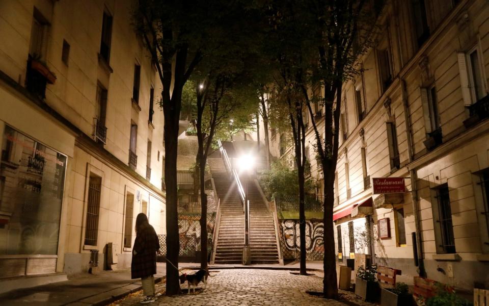 A woman walks her dog in Montmartre during the late-night curfew - REUTERS/Charles Platiau