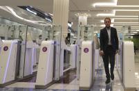 A man goes through an automated gate after he passed through the face and iris-recognition gate to board a plane, during a media tour at Dubai Airport, in the United Arab Emirates, Sunday, March 7, 2021. Dubai's airport, the world’s busiest for international travel, has introduced an iris-scanner that verifies one’s identity and eliminates the need for any human interaction when leaving the country. It’s the latest artificial intelligence program the UAE has launched amid the surging coronavirus pandemic. (AP Photo/Kamran Jebreili)