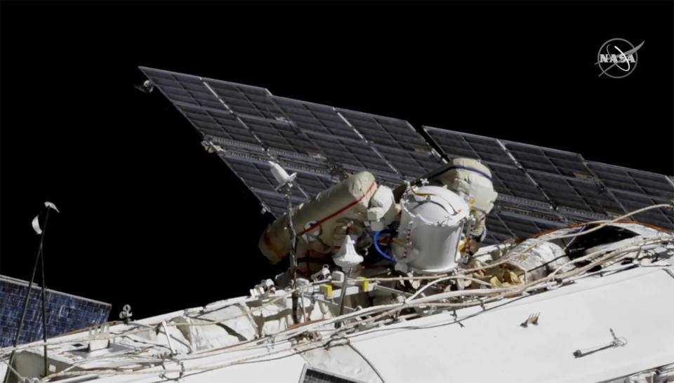 This photo provided by NASA shows Russian astronauts Commander Sergey Ryzhikov, left in red stripes, and Sergey Kud-Sverchkov on a spacewalk outside of the International Space Station on Wednesday, Nov. 18, 2020, as they prepare for next year's arrival of a long-delayed lab. (NASA via AP)