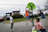 Sebastian Cervantes, de 9 años, a la izquierda, mira cómo Marvin Montoya, de 10 años, hace una clavada junto a Irvin Bahena, de 10 años, en Burlington, Carolina del Norte, el miércoles 11 de marzo de 2020 en un parque de casas rodantes con mayoría latina. (AP Foto/Jacquelyn Martin)